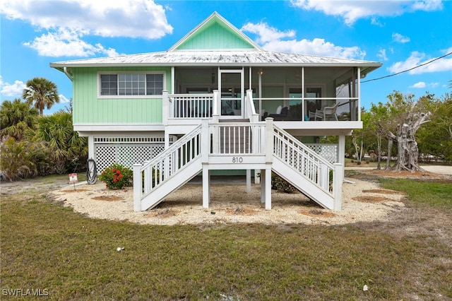 rear view of house with a yard and a sunroom