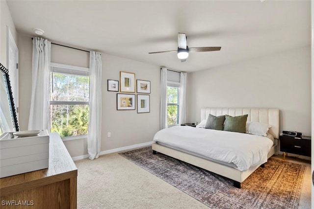 carpeted bedroom with multiple windows and ceiling fan