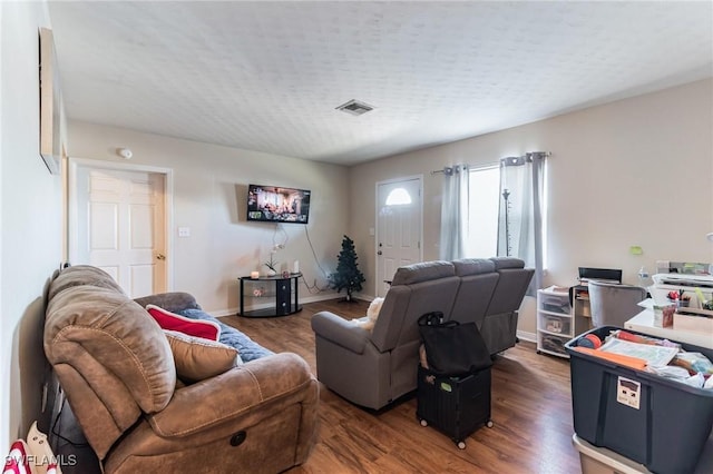 living room featuring dark hardwood / wood-style floors and a textured ceiling