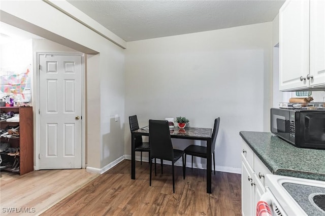 dining area with dark hardwood / wood-style flooring and a textured ceiling