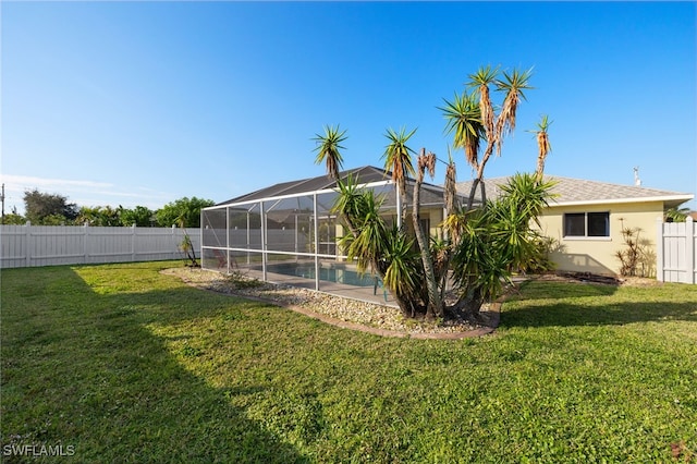 view of yard featuring a fenced in pool and glass enclosure