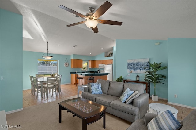 living room featuring light tile patterned floors, vaulted ceiling, and ceiling fan