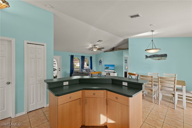 kitchen featuring pendant lighting, a kitchen island, vaulted ceiling, light tile patterned flooring, and light brown cabinets