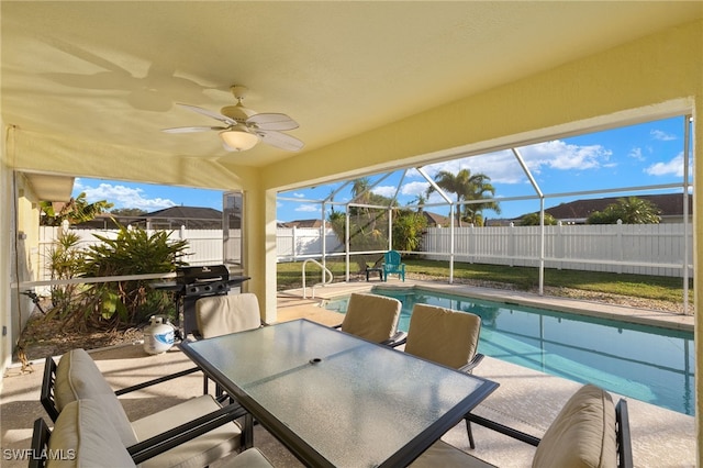 view of pool with area for grilling, a patio, ceiling fan, and glass enclosure