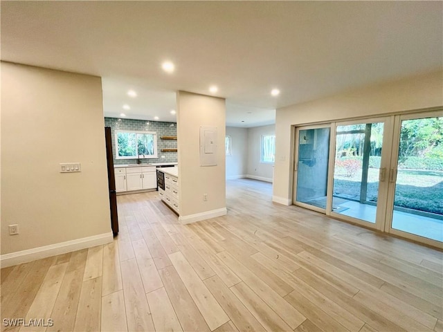 unfurnished living room with sink and light wood-type flooring