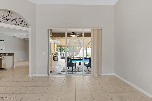 unfurnished dining area featuring light tile patterned floors and ceiling fan