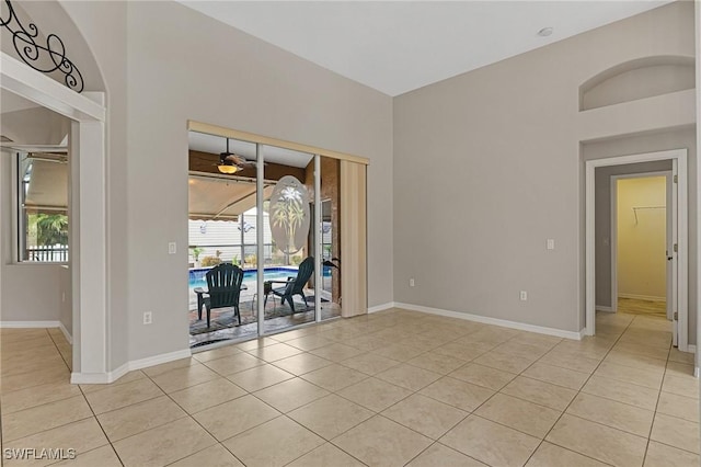 tiled empty room with ceiling fan and a healthy amount of sunlight