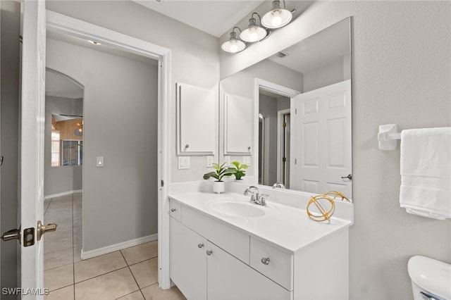 bathroom with tile patterned flooring, vanity, and toilet