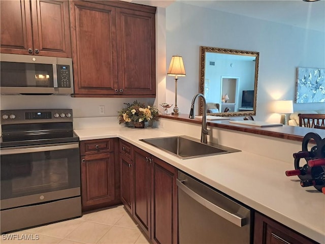 kitchen featuring appliances with stainless steel finishes, sink, and light tile patterned floors