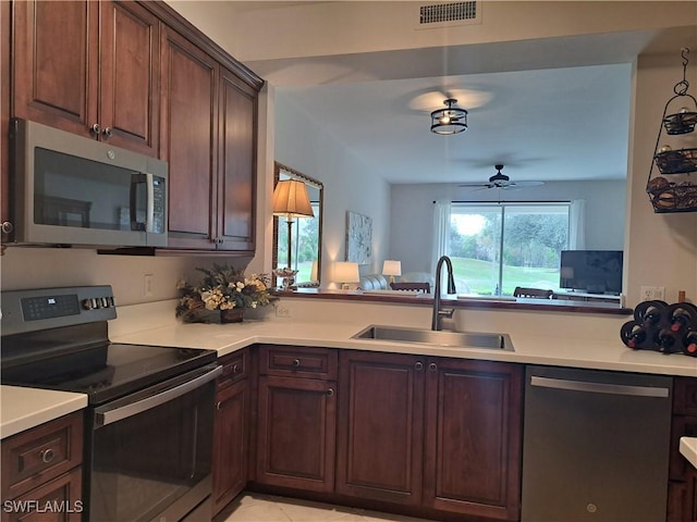 kitchen featuring sink, stainless steel appliances, kitchen peninsula, and ceiling fan