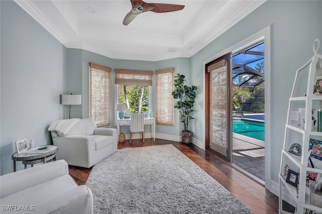 sitting room with a raised ceiling, ceiling fan, ornamental molding, and dark hardwood / wood-style flooring