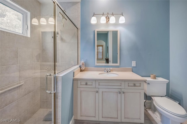 bathroom with vanity, toilet, and a shower with shower door