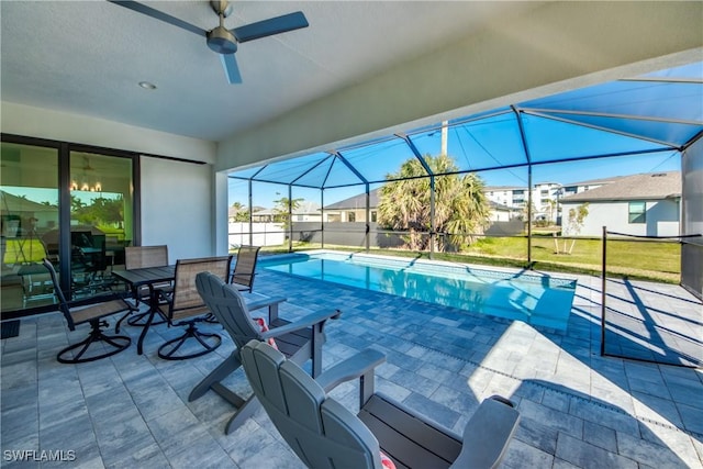 view of swimming pool featuring ceiling fan, a lanai, and a patio