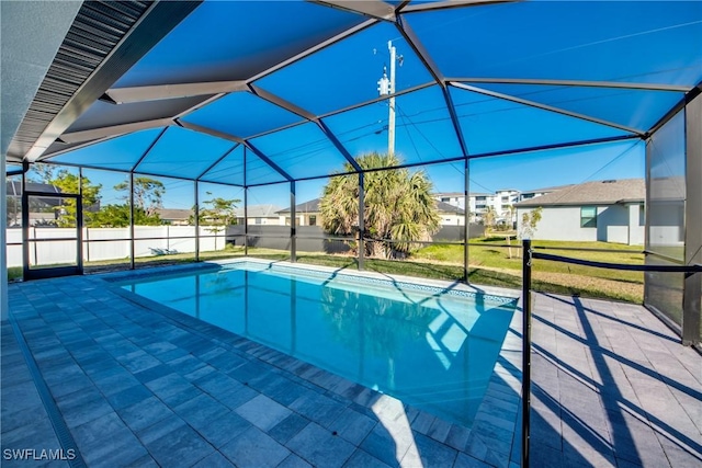 view of swimming pool with a lanai, a patio area, and a lawn