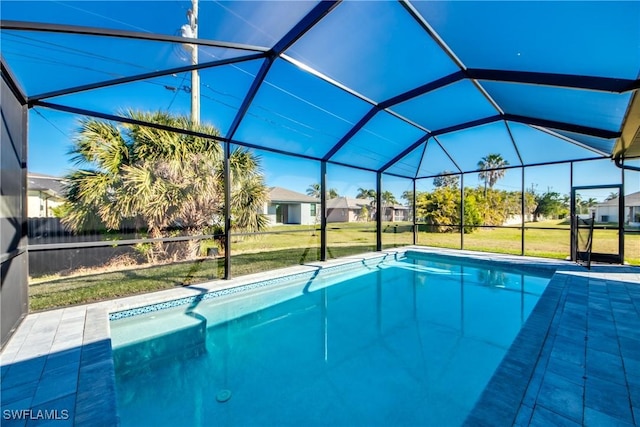 view of pool featuring a yard, a patio area, and glass enclosure