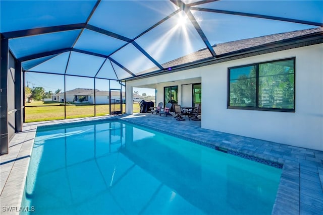 view of pool featuring a lanai, a patio, and a lawn