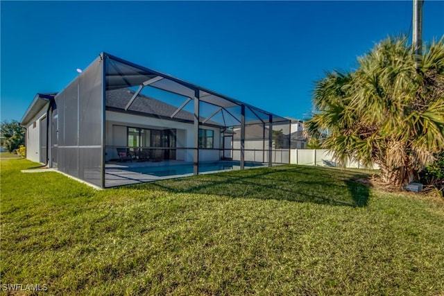 back of house featuring a patio, glass enclosure, and a lawn