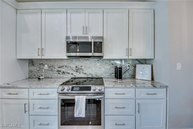 kitchen with white cabinetry, light stone countertops, tasteful backsplash, and stainless steel appliances