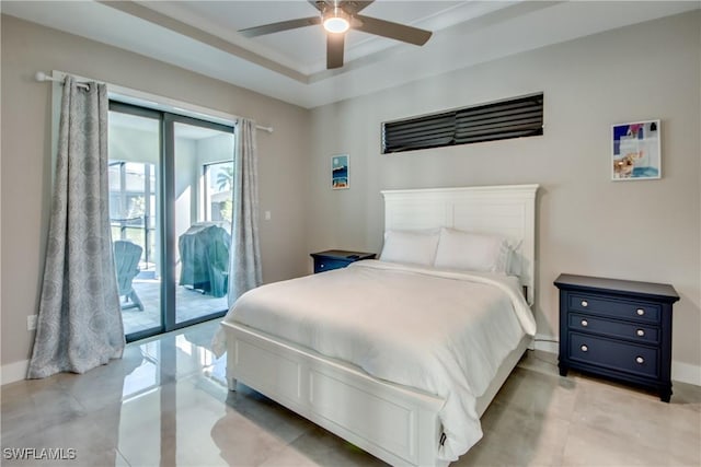 bedroom featuring ceiling fan, a tray ceiling, and access to outside