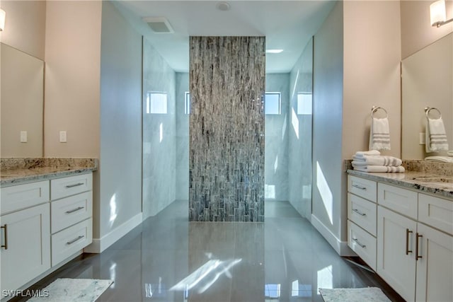 bathroom featuring vanity, plenty of natural light, and tiled shower