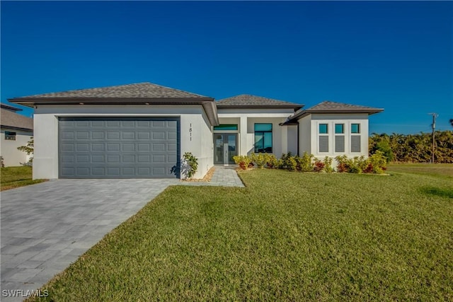 prairie-style house with a garage and a front lawn