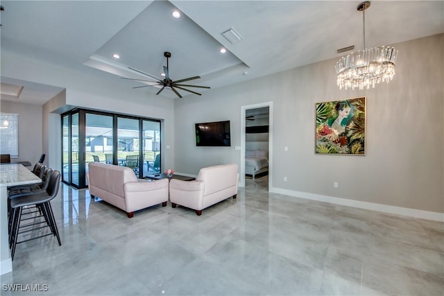 living room with a tray ceiling and ceiling fan