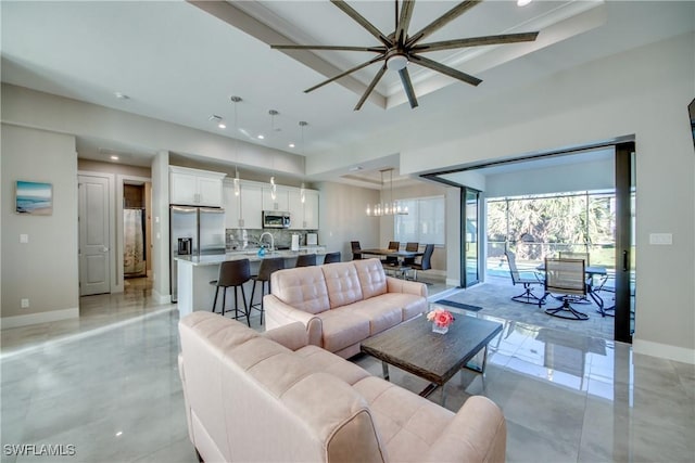 living room with a tray ceiling and a chandelier