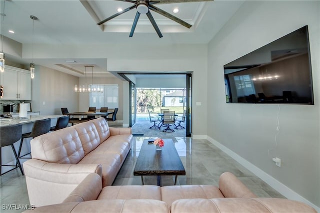 living room featuring a raised ceiling and ceiling fan