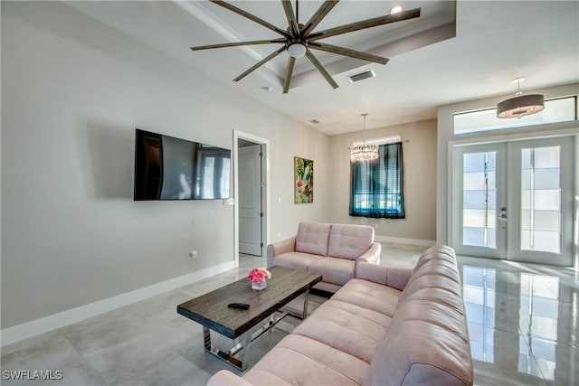 living room featuring french doors and a tray ceiling