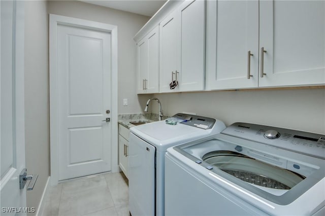 washroom featuring washer and dryer, sink, light tile patterned floors, and cabinets