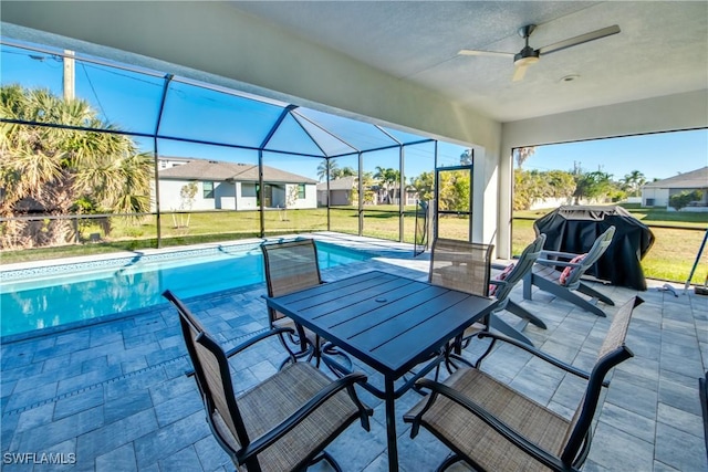 view of pool featuring ceiling fan, a yard, glass enclosure, and a patio area