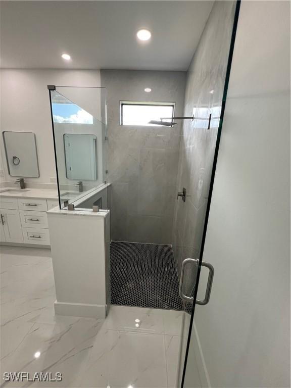 bathroom featuring vanity and a shower with door