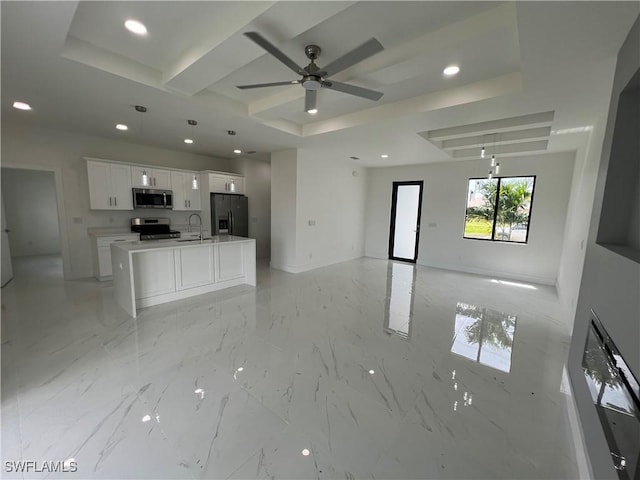 kitchen featuring white cabinetry, a center island with sink, a tray ceiling, ceiling fan, and stainless steel appliances