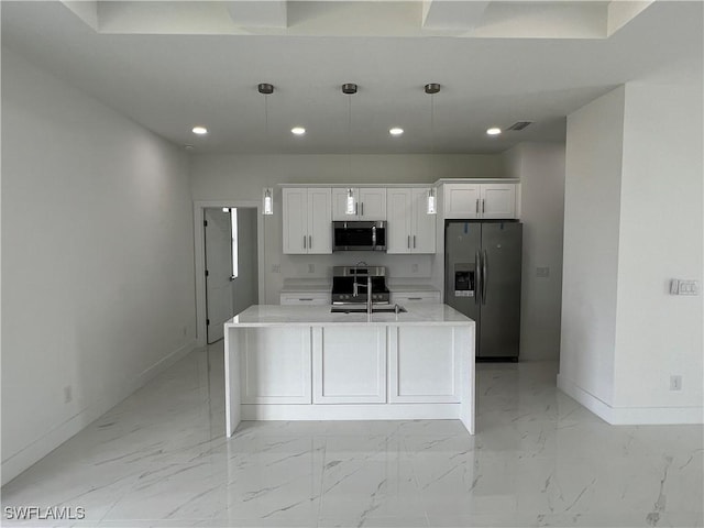 kitchen with white cabinetry, appliances with stainless steel finishes, an island with sink, and pendant lighting