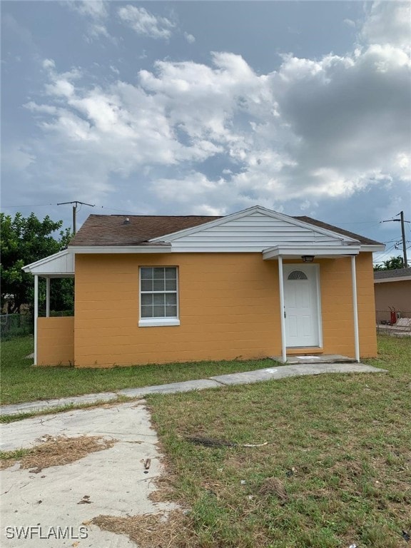 rear view of property featuring a yard