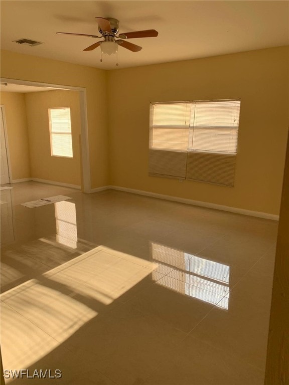 unfurnished room with tile patterned floors and ceiling fan