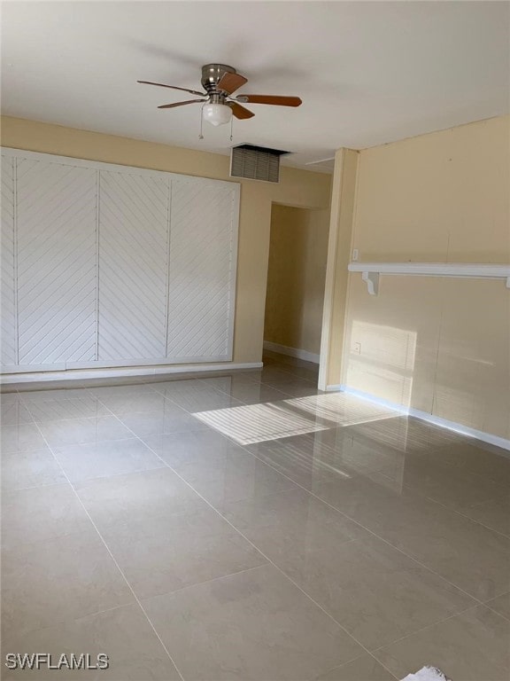 tiled empty room with ceiling fan