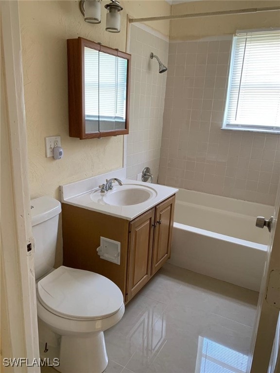 full bathroom featuring vanity, tile patterned flooring, toilet, and tiled shower / bath