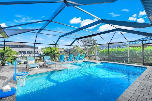 view of pool with a patio area and glass enclosure