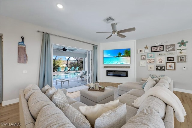 living room featuring light hardwood / wood-style flooring and ceiling fan