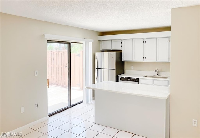 kitchen featuring sink, stainless steel fridge, dishwasher, a textured ceiling, and light tile patterned flooring