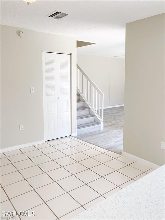 tiled spare room with a textured ceiling