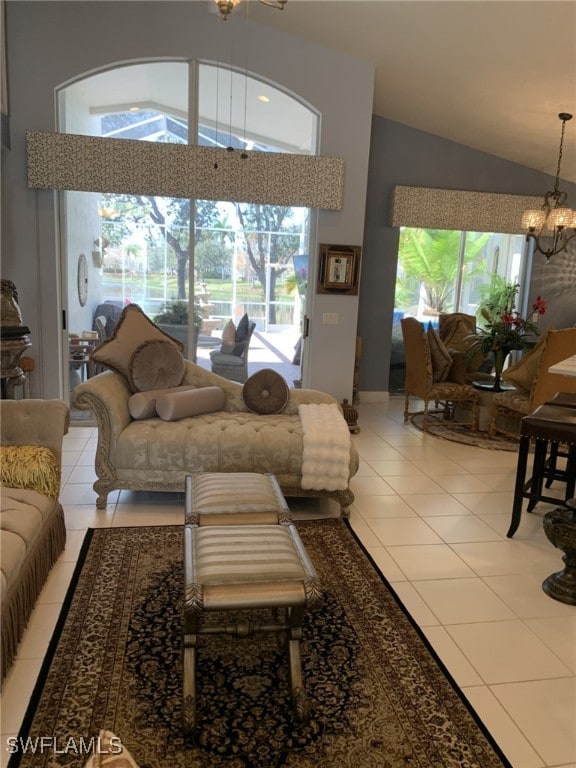 tiled living room featuring plenty of natural light, high vaulted ceiling, and an inviting chandelier