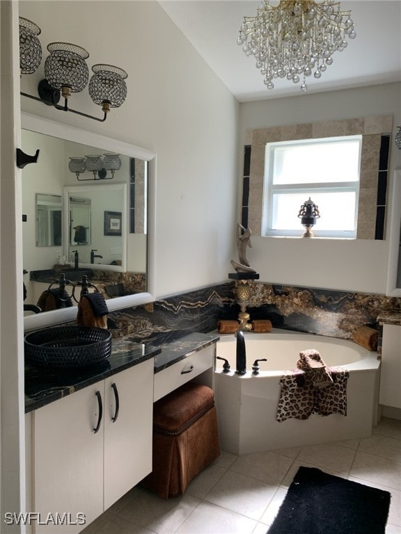 bathroom with vanity, tile patterned flooring, a chandelier, and a bathing tub