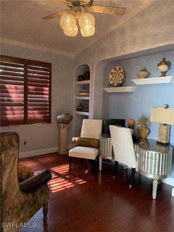 living area featuring crown molding, built in shelves, wood-type flooring, and ceiling fan