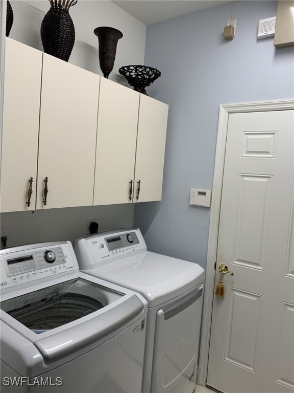 laundry area with cabinets and washing machine and clothes dryer