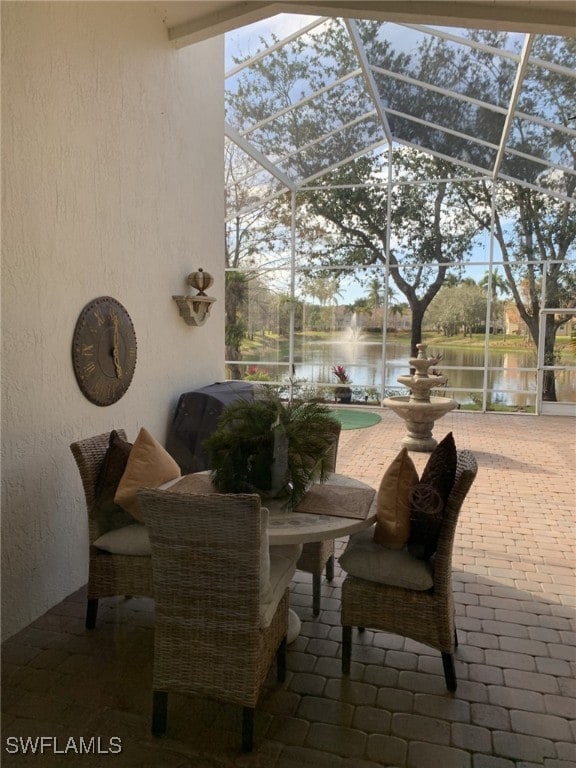 view of patio / terrace with a water view and glass enclosure