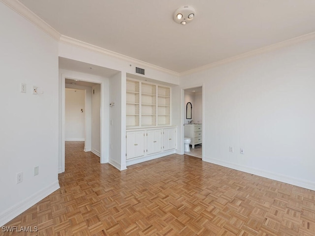 unfurnished room featuring crown molding, built in shelves, and light parquet floors