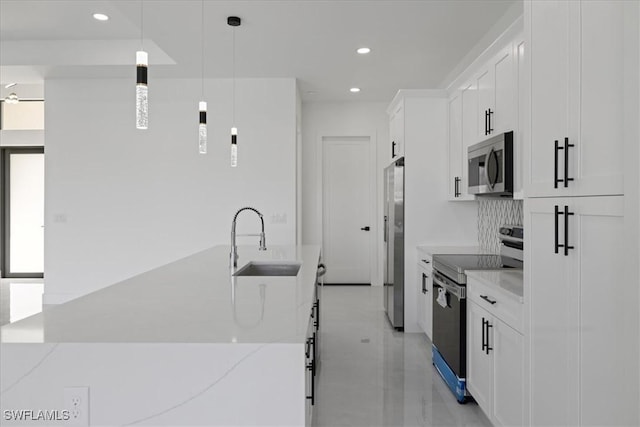 kitchen featuring sink, white cabinetry, light stone counters, decorative light fixtures, and stainless steel appliances