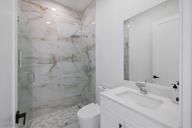 bathroom featuring vanity, toilet, and a shower with door